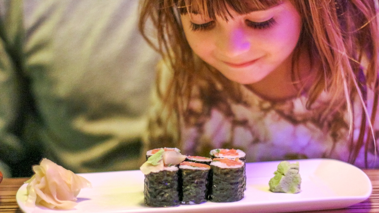 a little girl eating sushi